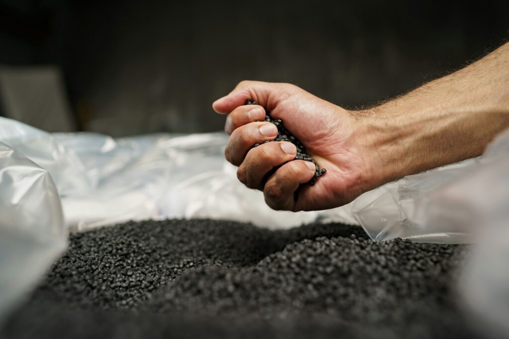 Close up of male hand holding plastic polymer granules