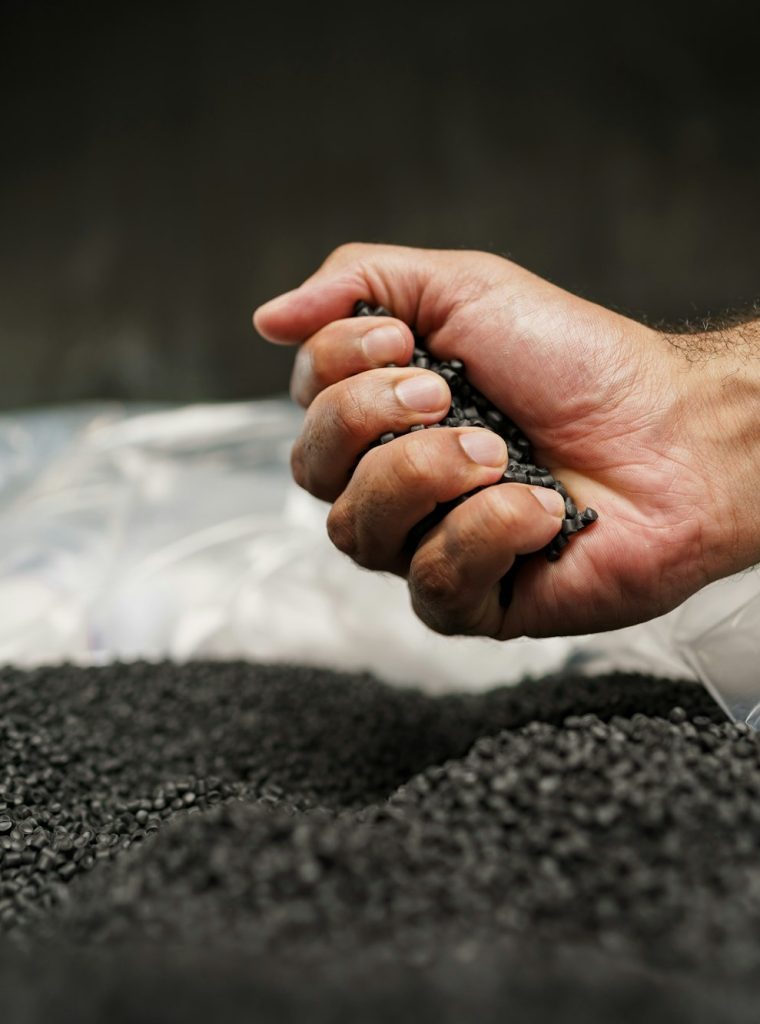 Close up of male hand holding plastic polymer granules