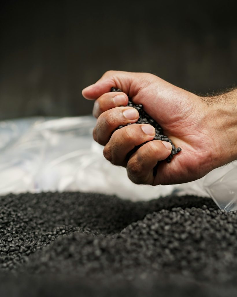 Close up of male hand holding plastic polymer granules